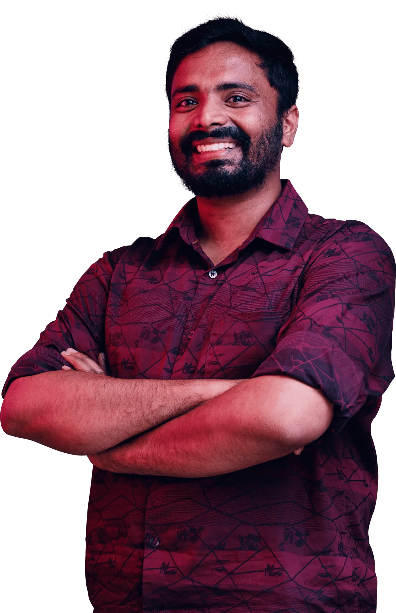 Smiling man with a beard wearing a maroon checkered shirt and arms crossed.