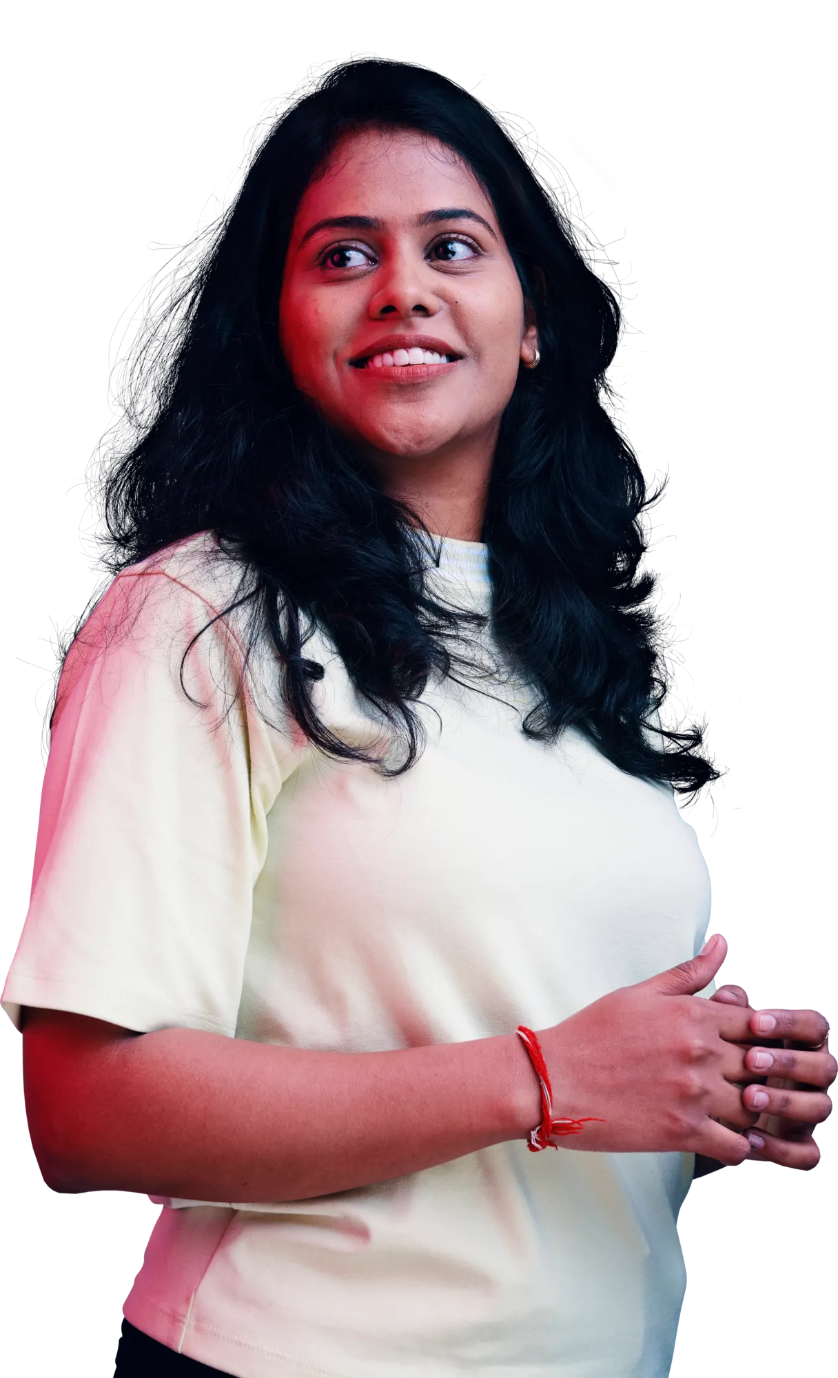 A smiling woman with long dark hair wearing a light-colored T-shirt, with her hands clasped in front.